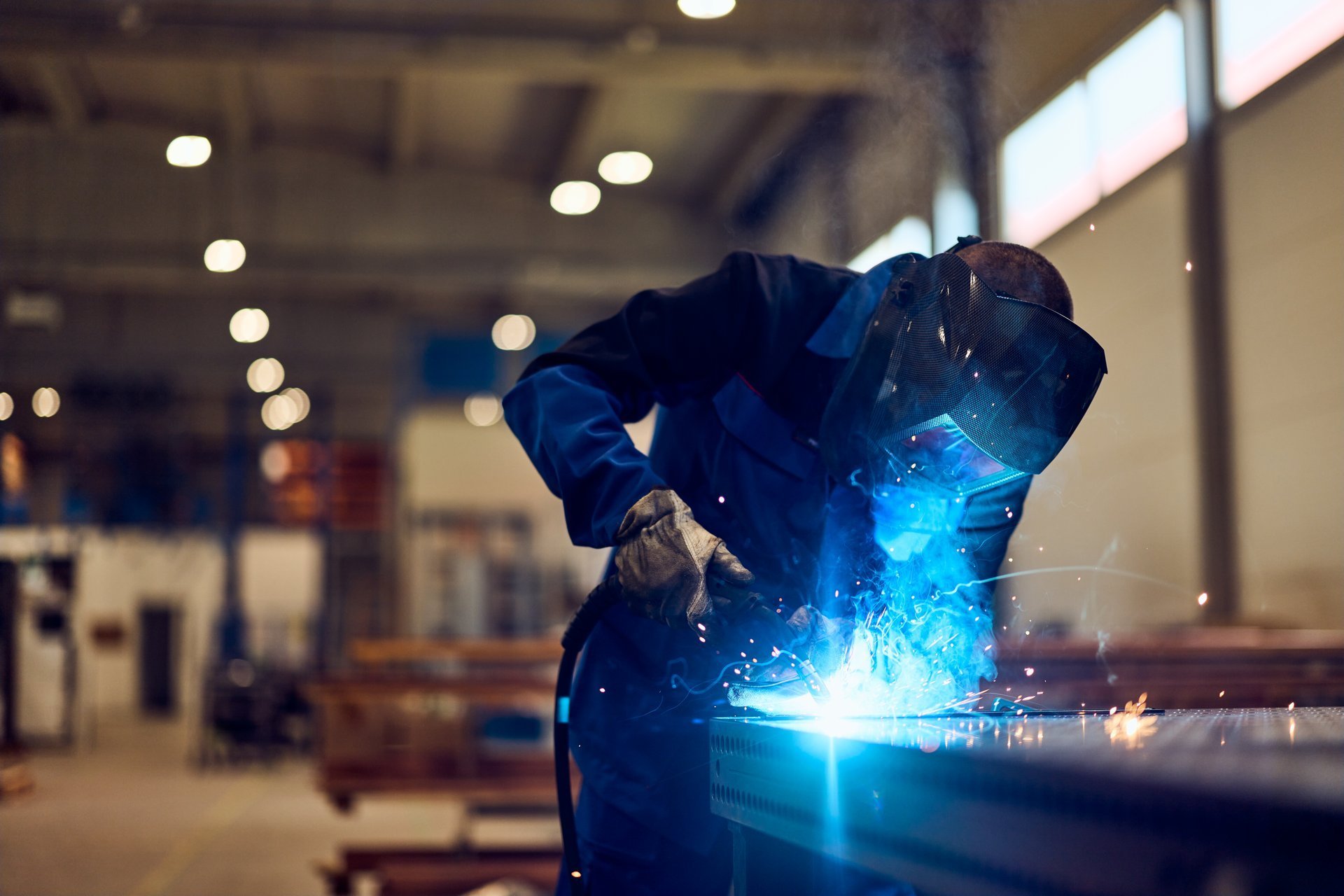 Man working in a factory operating welding machinery