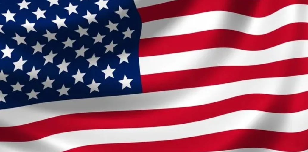 The American flag waving with blue canton containing white stars and red and white stripes